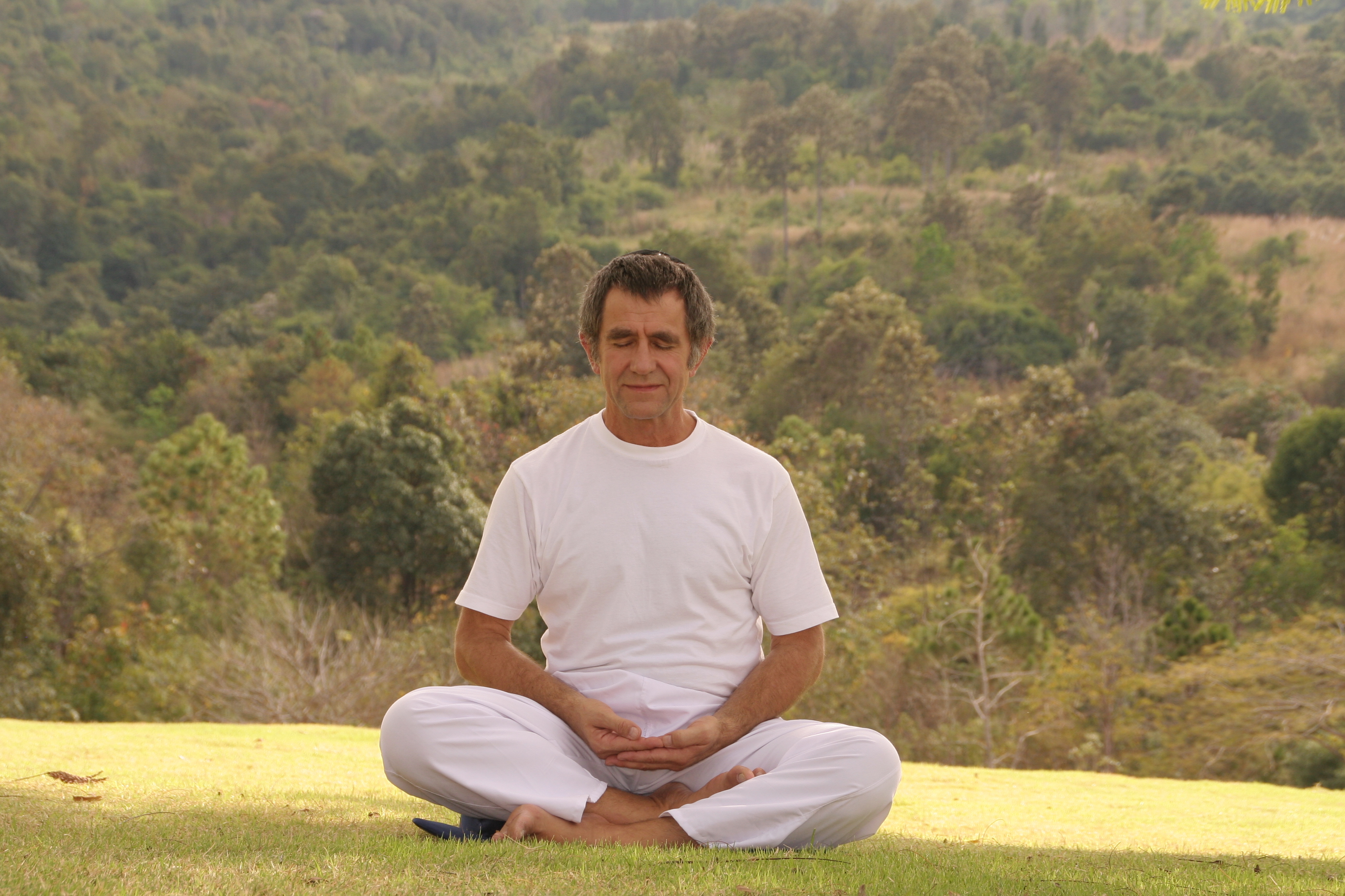 Axel Kiezbett Wunschkunde im Yoga-Sitz vor Landschaft