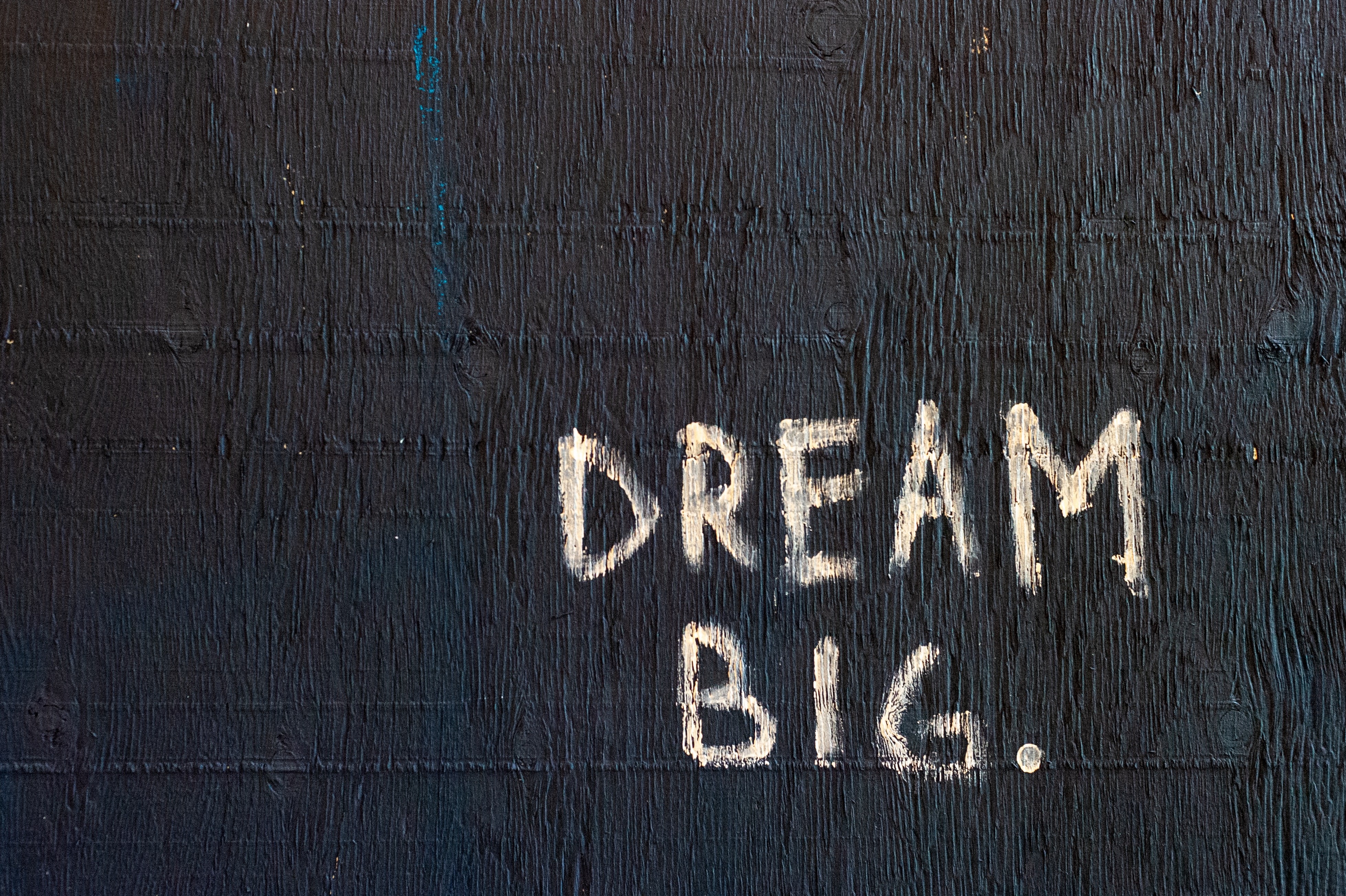 Schriftzug "Dream big" auf schwarzer Wand