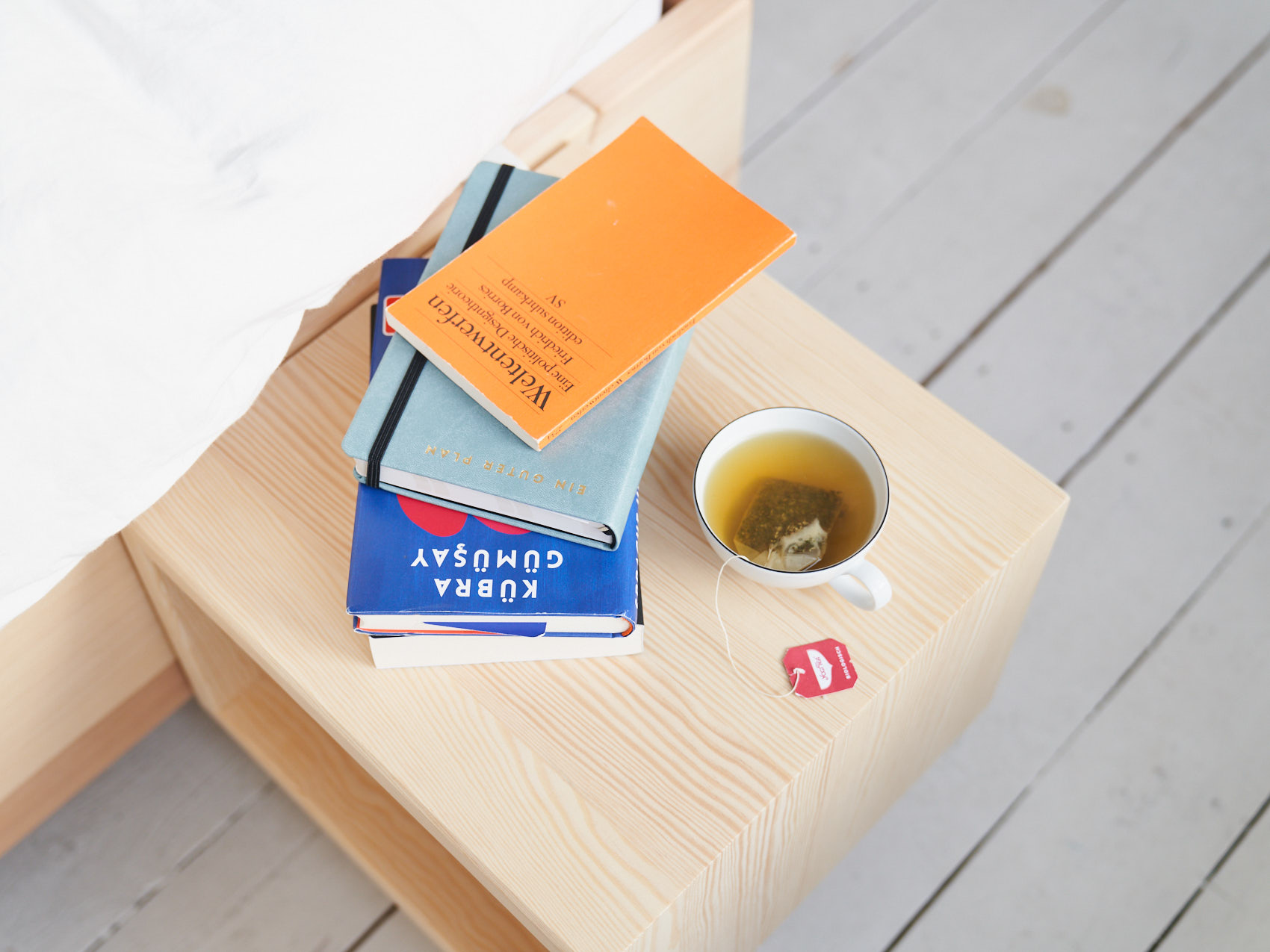Bücher und Tee auf Kiezbett Nachttisch