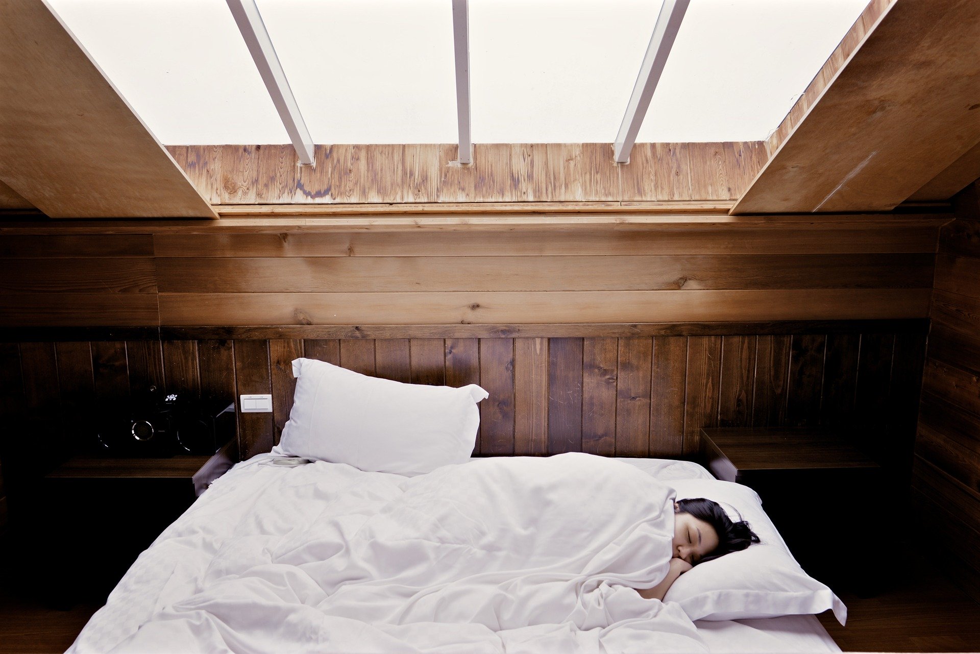 Frau schläft in weichem Bett in Raum aus Holz